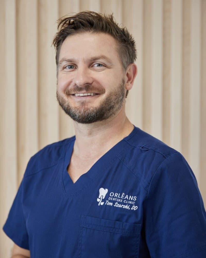 Portrait of denturist Tom Szarski in navy scrubs